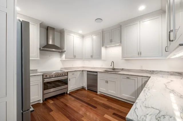 a kitchen with stainless steel appliances granite countertop a sink stove and refrigerator