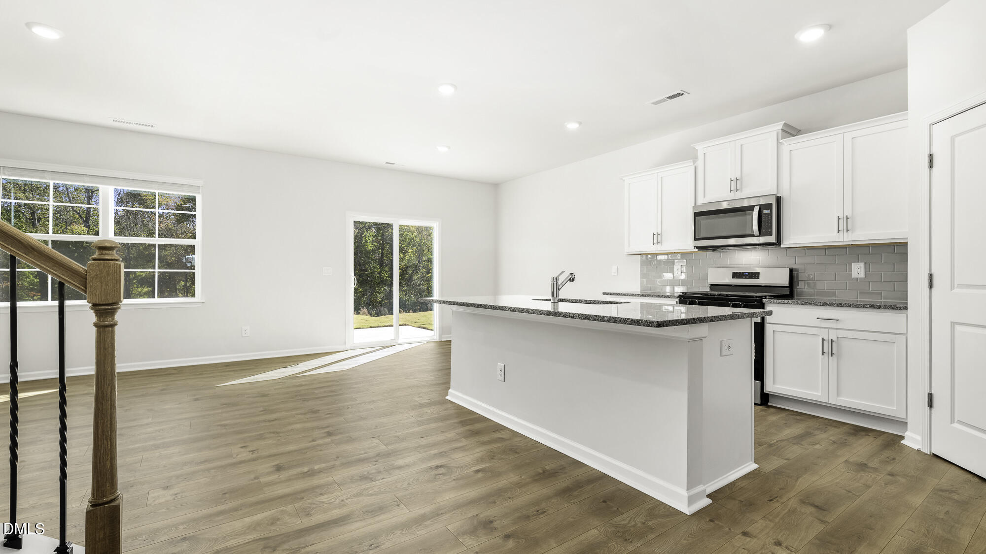1376 Lansdowne Drive Mebane, NC 27302 - Photo 5 of 22 a kitchen with granite countertop a stove top oven a sink a refrigerator and white cabinets with wooden floor