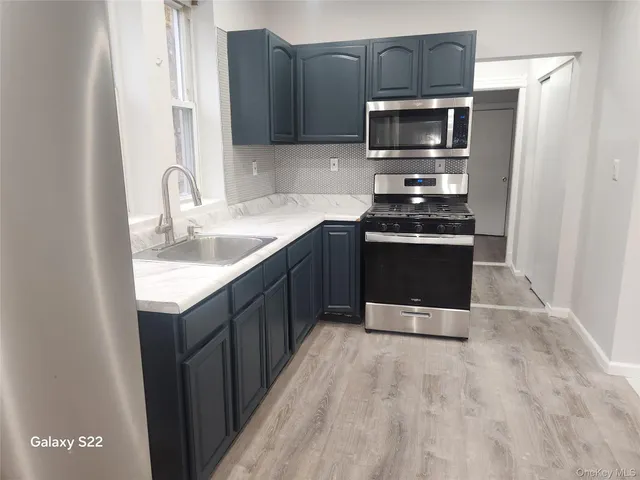 a kitchen with stainless steel appliances granite countertop a stove a microwave and a sink