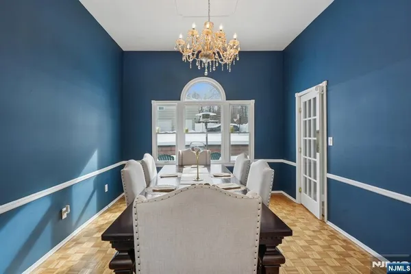 a dining room with furniture a chandelier and wooden floor