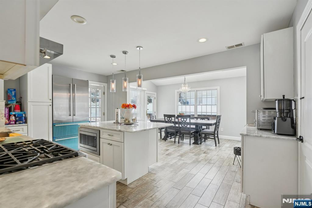 25 Nathan Way Wayne, NJ 07470 - Photo 16 of 36 a kitchen with stainless steel appliances a table and chairs in it