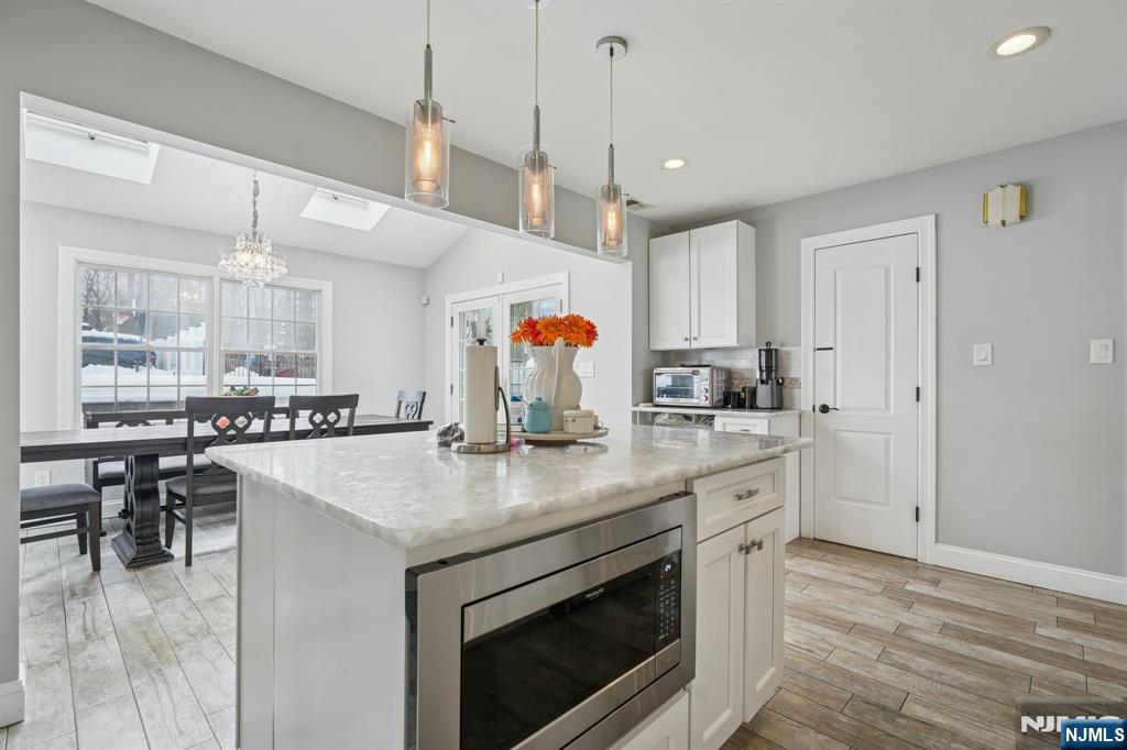 25 Nathan Way Wayne, NJ 07470 - Photo 17 of 36 a kitchen with a stove a sink a dining table and chairs