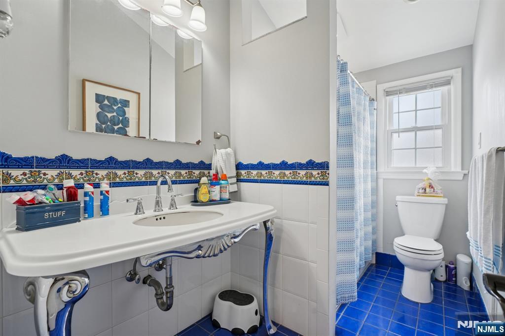 25 Nathan Way Wayne, NJ 07470 - Photo 26 of 36 a bathroom with a sink a toilet and a mirror