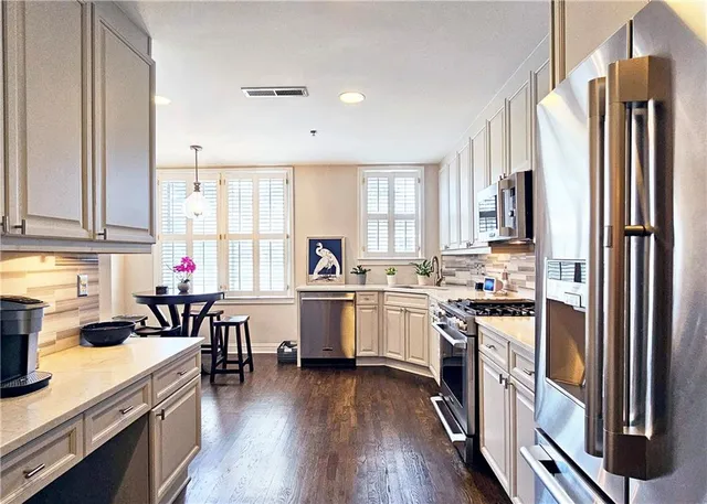 a kitchen with white cabinets and appliances