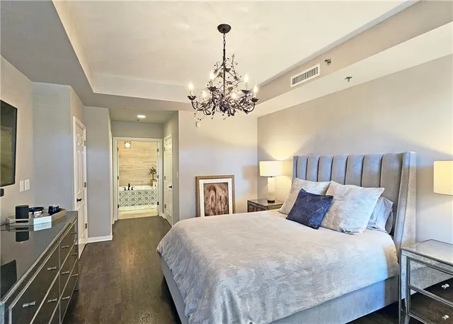 a bedroom with a large bed and a chandelier