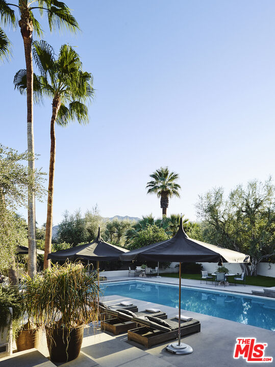 40471 Sand Dune Road Rancho Mirage, CA 92270 - Photo 35 of 42 a view of a swimming pool with a table and chairs