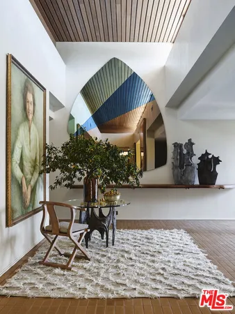 a table with chairs and a vase of pink flowers