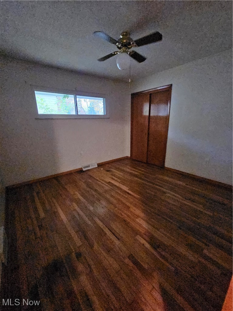 945 West Schaaf Road Cleveland, OH 44109 - Photo 10 of 27 Unfurnished bedroom featuring a closet, dark hardwood / wood-style floors, a textured ceiling, and ceiling fan