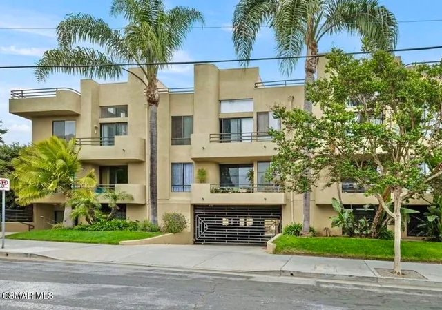 a front view of residential houses with yard and trees