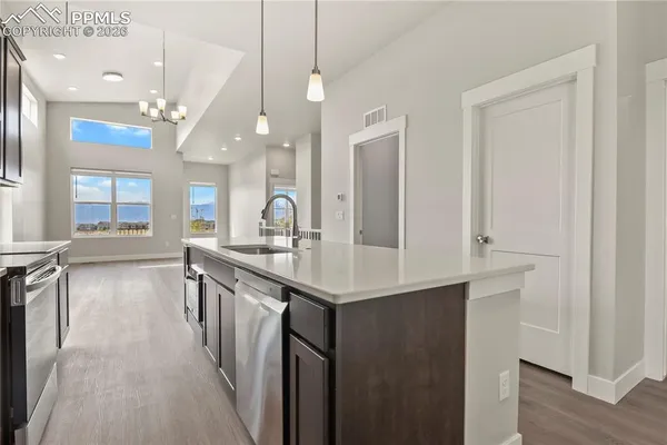 a kitchen with kitchen island a sink appliances and a counter top space
