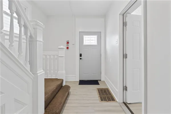 a hallway with wooden floor windows and stairs