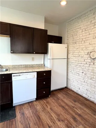 a kitchen with a wooden floor and a refrigerator