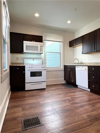 a kitchen with stainless steel appliances kitchen island granite countertop a stove a sink and a microwave