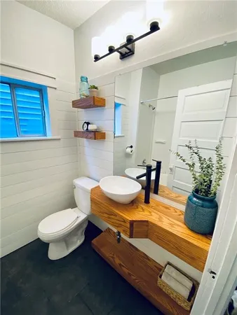 a bathroom with a sink a toilet and a mirror