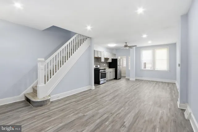 a view of a livingroom with wooden floor and stairs
