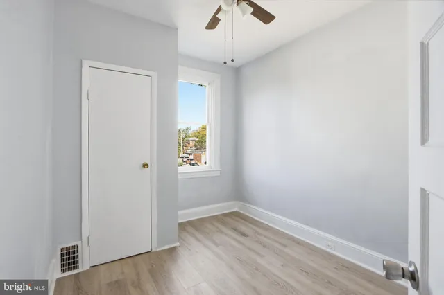 an empty room with a window and wooden floor