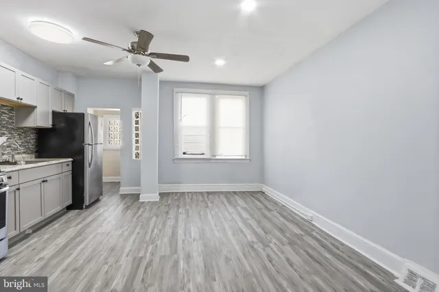 a view of a kitchen with a fridge wooden floor and a window