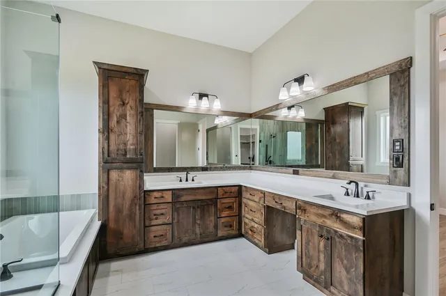an empty room with wooden floor chandelier fan and windows