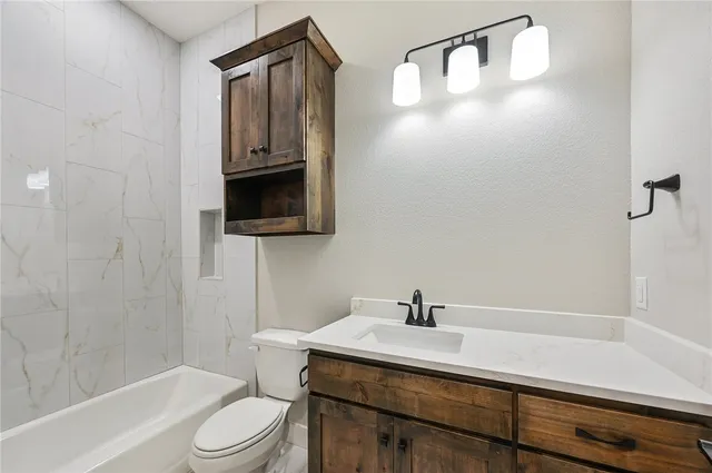 an empty room with wooden floor chandelier fan and windows