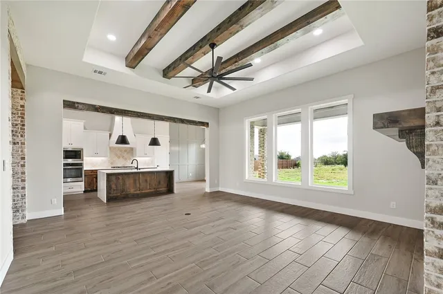 a kitchen with stainless steel appliances granite countertop a sink a stove and a wooden floors