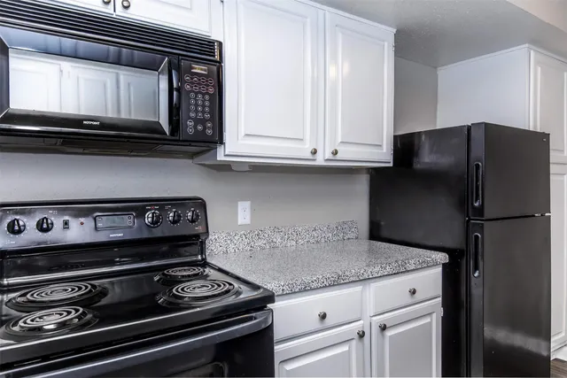 a kitchen with granite countertop a stove and a microwave