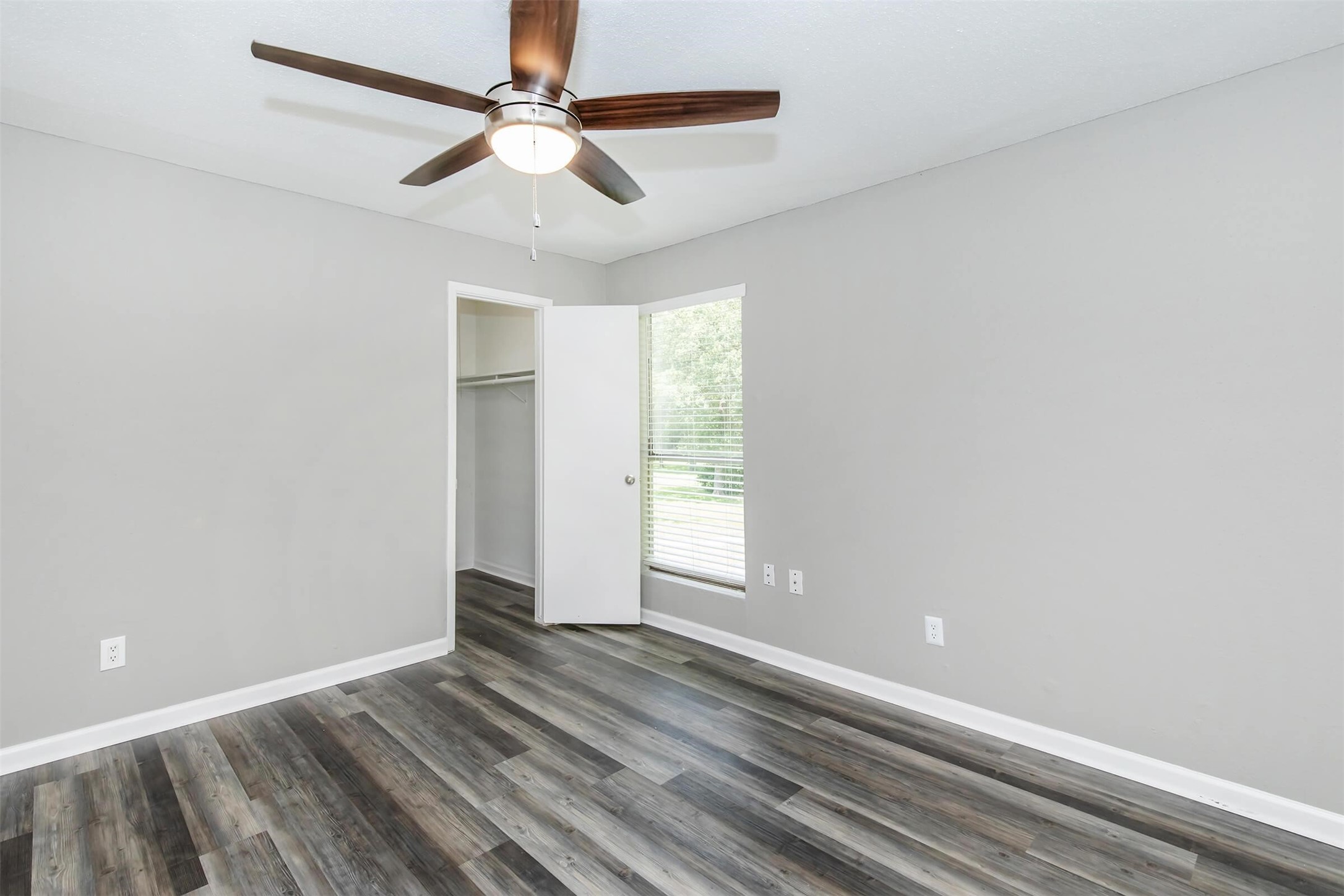 18001 Cypress Trace Road, Unit 1208 Houston, TX 77090 - Photo 9 of 34 an empty room with wooden floor fan and windows