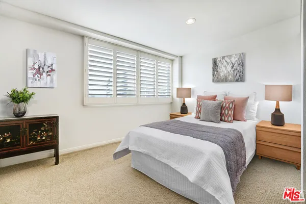 a spacious bedroom with a bed a couch and a window