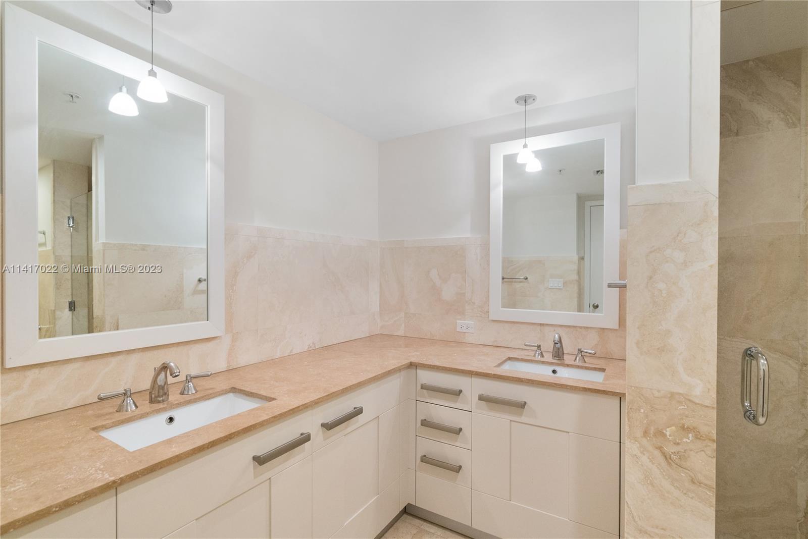 3540 Main Highway, Unit 309 Miami, FL 33133 - Photo 23 of 34 a bathroom with a sink double vanity and a mirror