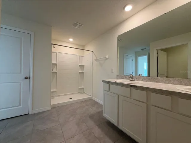 a bathroom with a shower sink and mirror