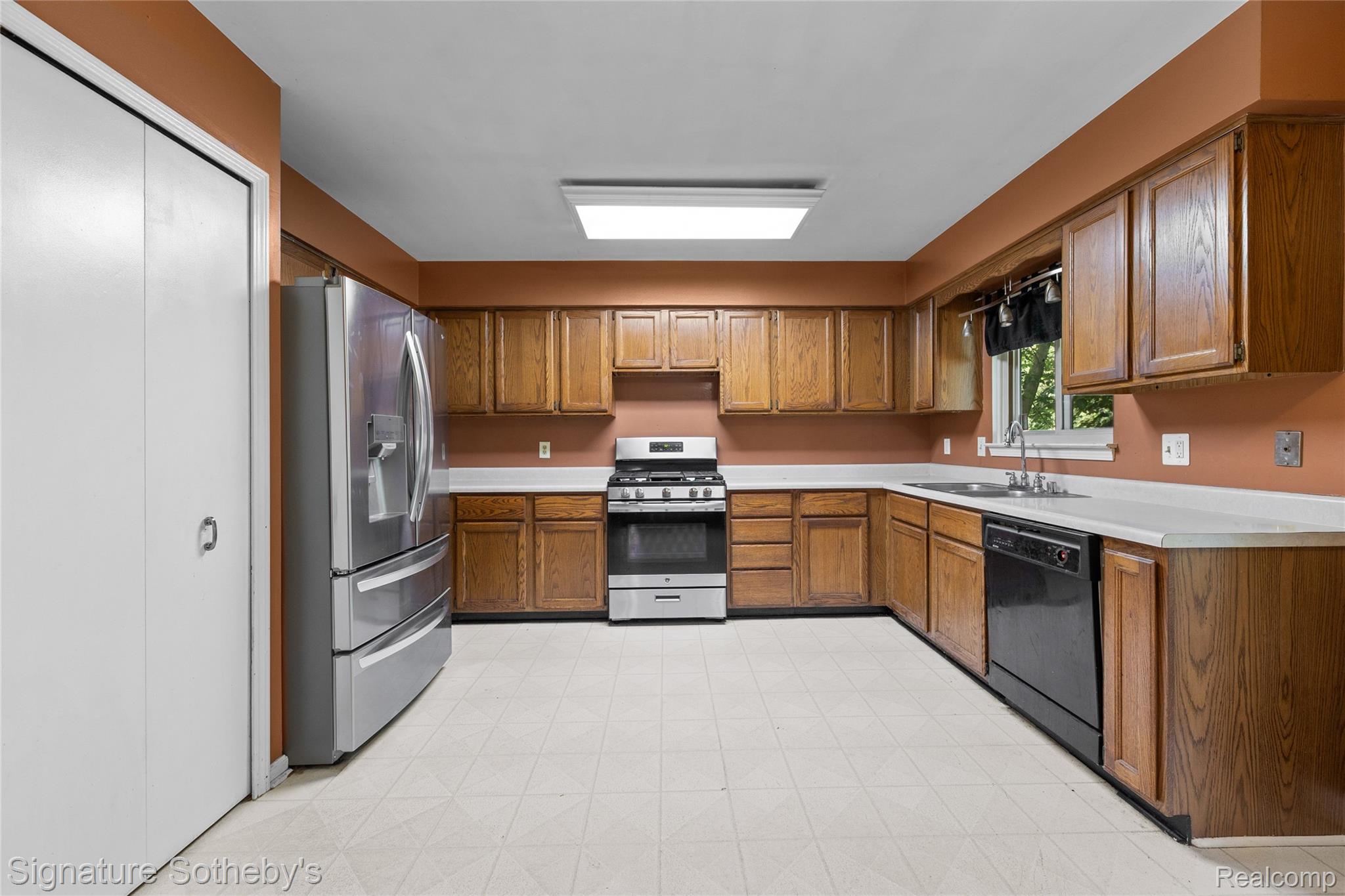 Kitchen featuring wood cabinetry, light countertops, and a white tiled floor