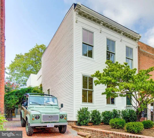 a car parked in front of a white house