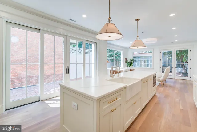 a large kitchen with kitchen island a large window and wooden floor
