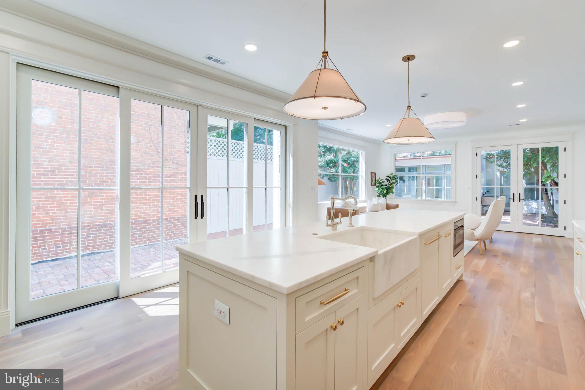 311 5th Street Southeast Washington, DC 20003 - Photo 12 of 21 a large kitchen with kitchen island a large window and wooden floor