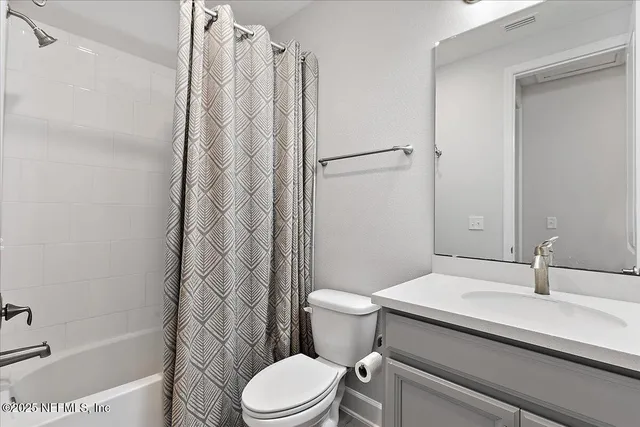 a white toilet sitting next to a bath tub