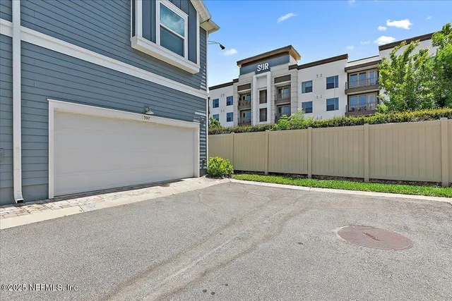 a front view of a building with a road and garage