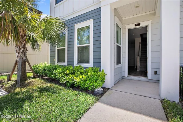 front view of a house with a yard and potted plants