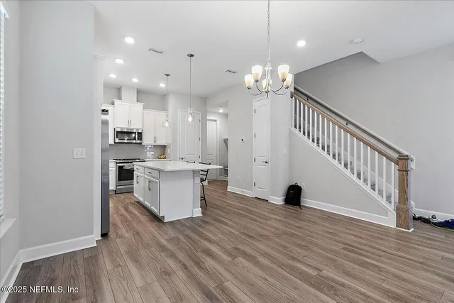 an open kitchen with white cabinets and stainless steel appliances