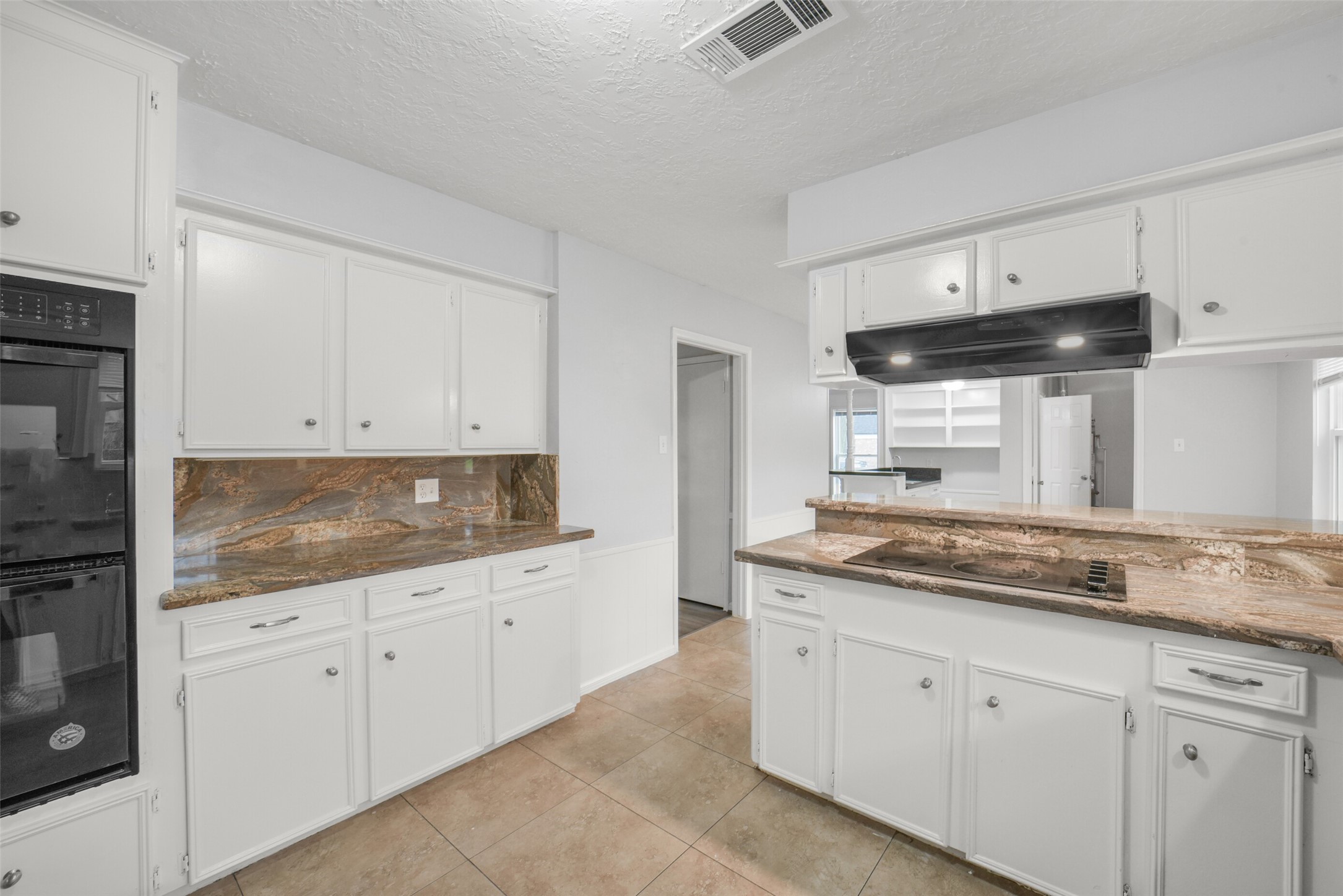 7611 Theisswood Road Spring, TX 77379 - Photo 13 of 41 Bright kitchen with classic white cabinetry, double ovens, and ample counter space.