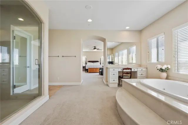 a large en suite bathroom with a large tub and mirror