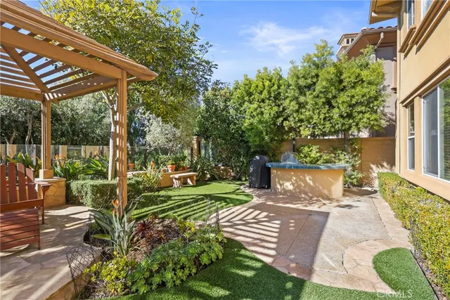 a view of a patio with table and chairs potted plants and large tree