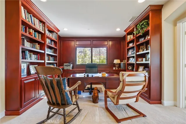 a view of a workspace with furniture and a bookshelf