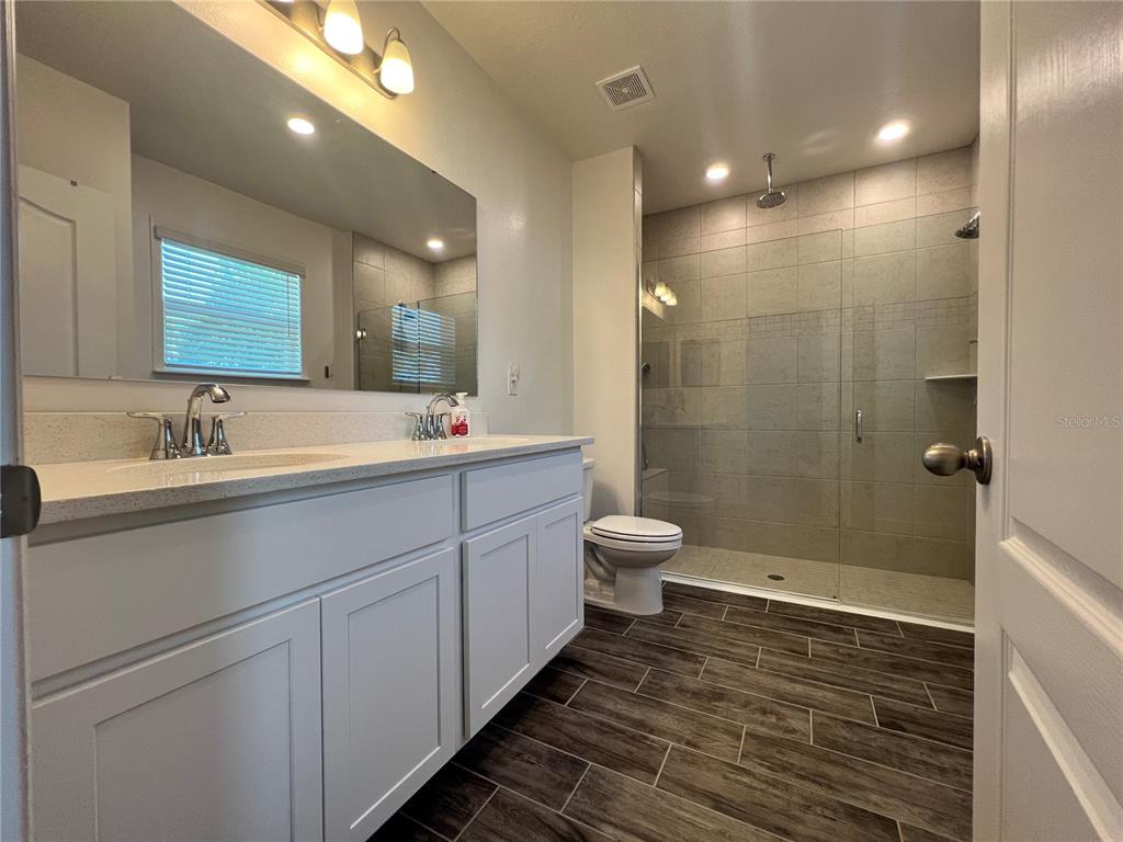 301 Jackson Loop DeLand, FL 32724 - Photo 12 of 22 a bathroom with a double vanity sink toilet and shower