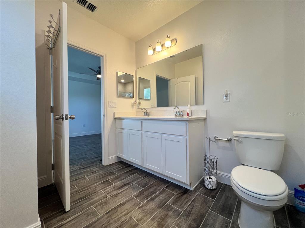 301 Jackson Loop DeLand, FL 32724 - Photo 13 of 22 a bathroom with a toilet sink and mirror