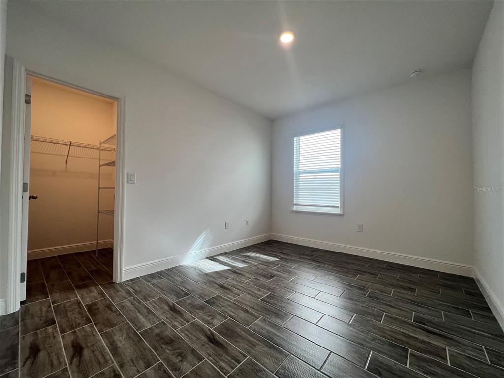 301 Jackson Loop DeLand, FL 32724 - Photo 14 of 22 an empty room with wooden floor and windows