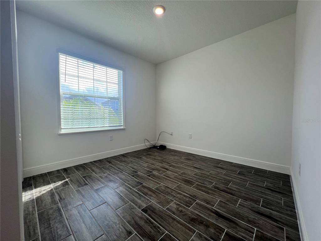 301 Jackson Loop DeLand, FL 32724 - Photo 17 of 22 a view of an empty room with wooden floor and a window
