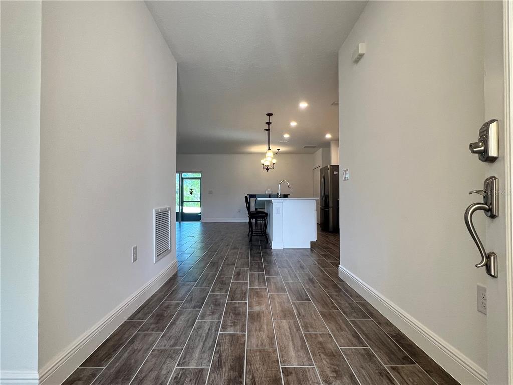 301 Jackson Loop DeLand, FL 32724 - Photo 3 of 22 a view of a hallway with wooden floor