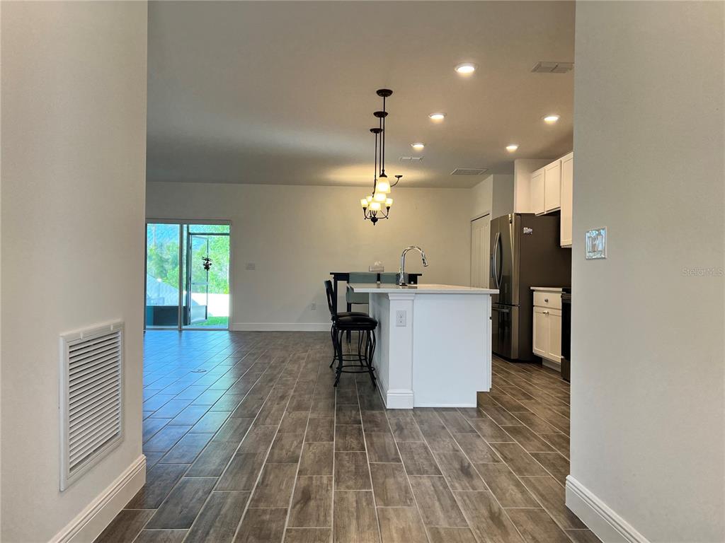 301 Jackson Loop DeLand, FL 32724 - Photo 4 of 22 a kitchen with a sink chandelier and refrigerator