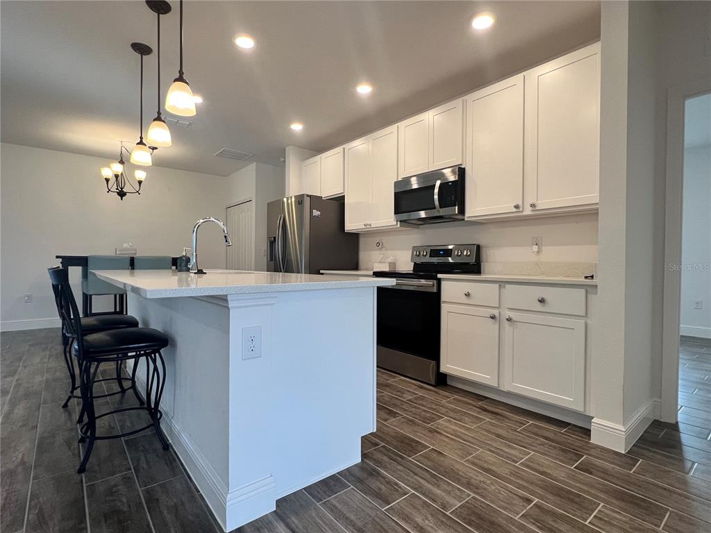 301 Jackson Loop DeLand, FL 32724 - Photo 5 of 22 a kitchen with cabinets a sink and appliances