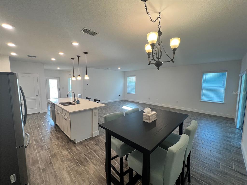301 Jackson Loop DeLand, FL 32724 - Photo 9 of 22 a kitchen with a table chairs and wooden floor