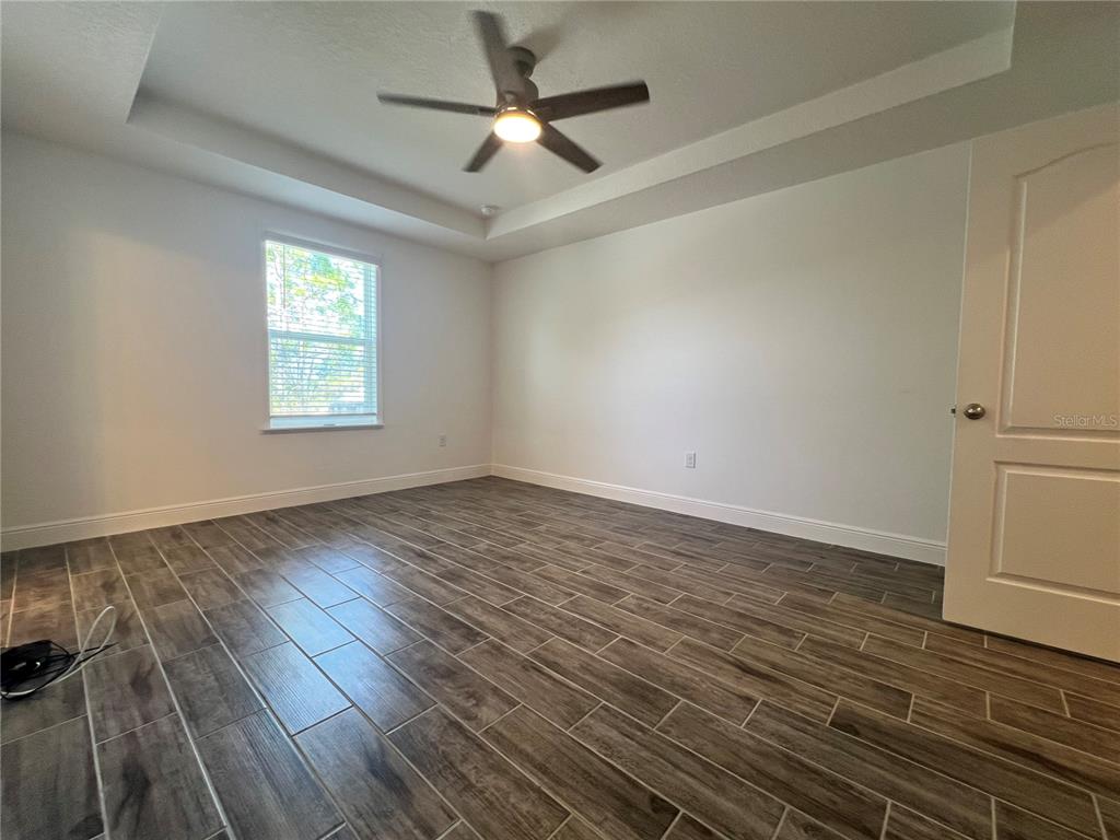 301 Jackson Loop DeLand, FL 32724 - Photo 10 of 22 wooden floor in an empty room with a window